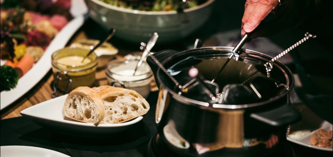 Gemütliches Fondue in der Luxuslodge bei winterlichen Verhältnissen