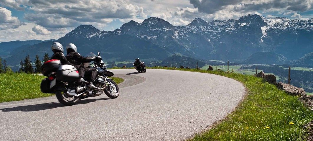 Fahrt um Kurve in den Alpen mit Motorrad