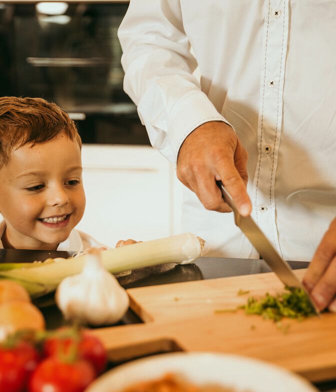 Kinder sieht dem Vater beim Kochen zu.