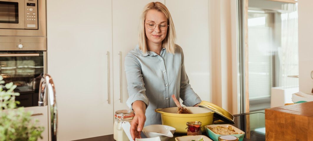 Genuss-Packages werden in der Luxuslodge von junger Frau fertiggekocht