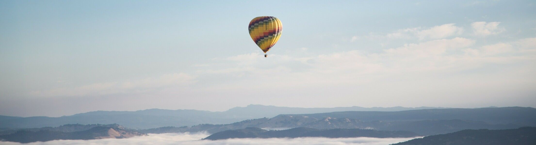Heißluftballon in der Lut bei blauem Himmel