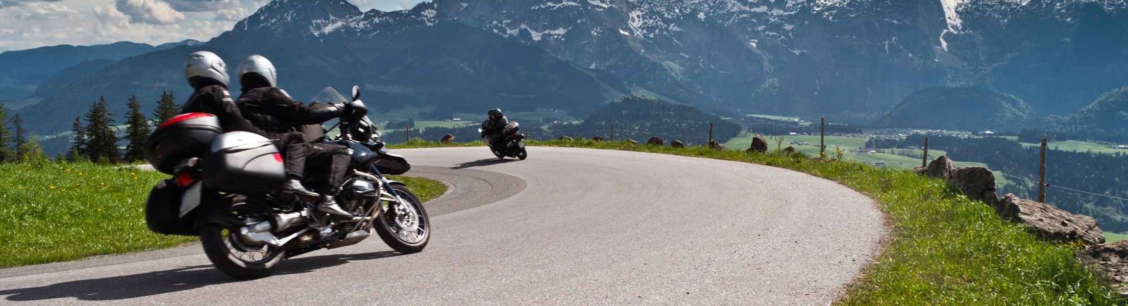 Motorradfahrer in Kurve in den Alpen