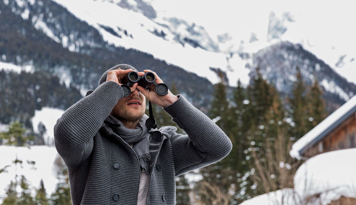 Mann erforscht winterliche Umgebung mit Fernglas in Annaberg